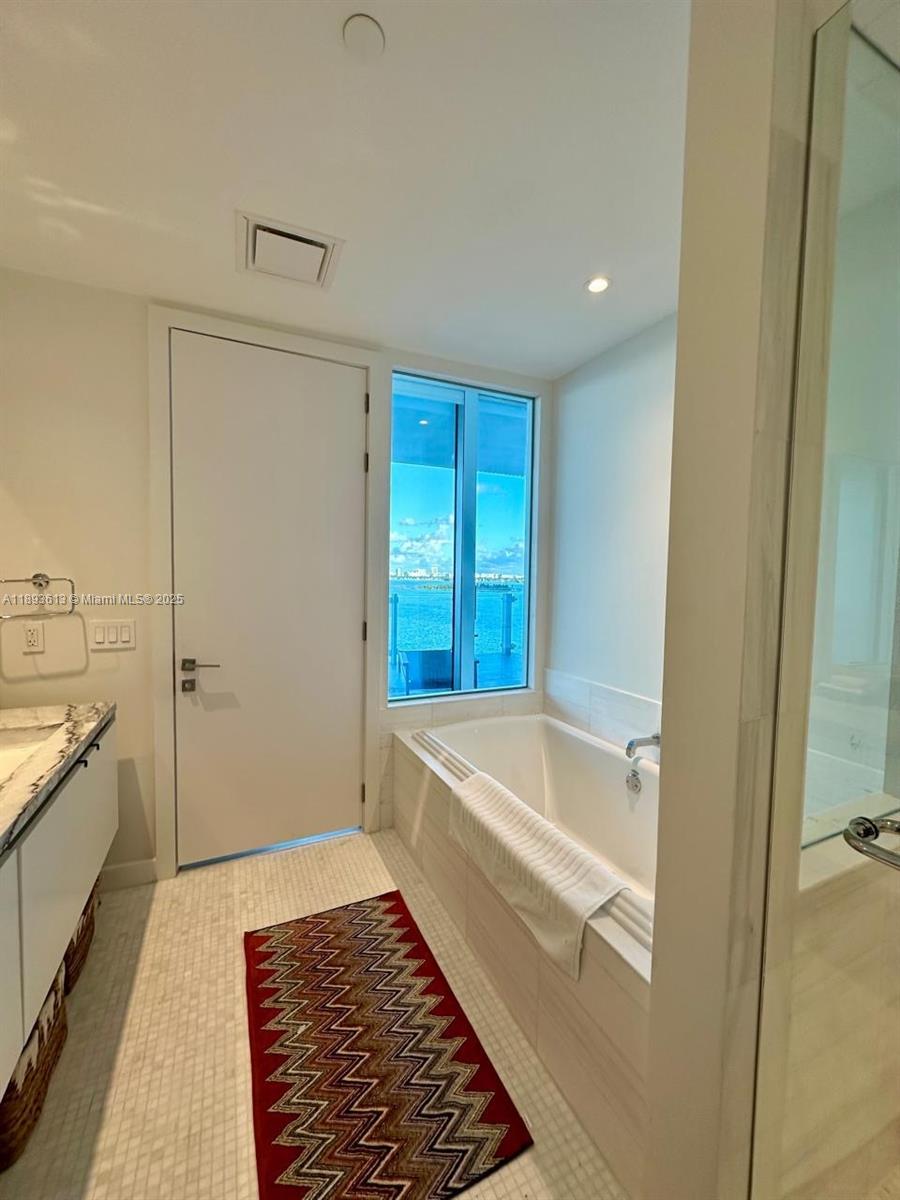 700 Northeast 26th Terrace, Unit 803 Miami, FL 33137 - Photo 9 of 13 a bathroom with a bathtub and a shower