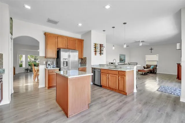 a kitchen with stainless steel appliances kitchen island wooden floors and white cabinets