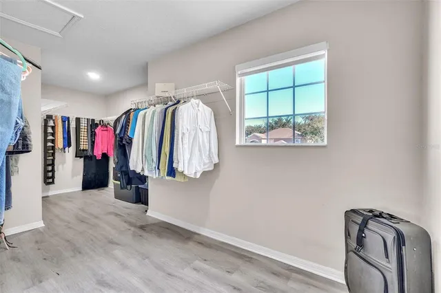 a view of walk in closet with clothes and shoes