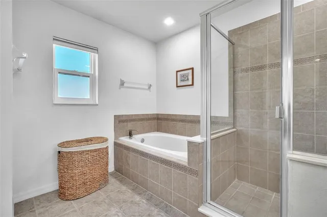 a bathroom with a tub a rug and white shower