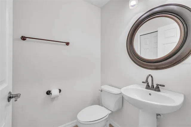 a bathroom with a sink a toilet and a mirror