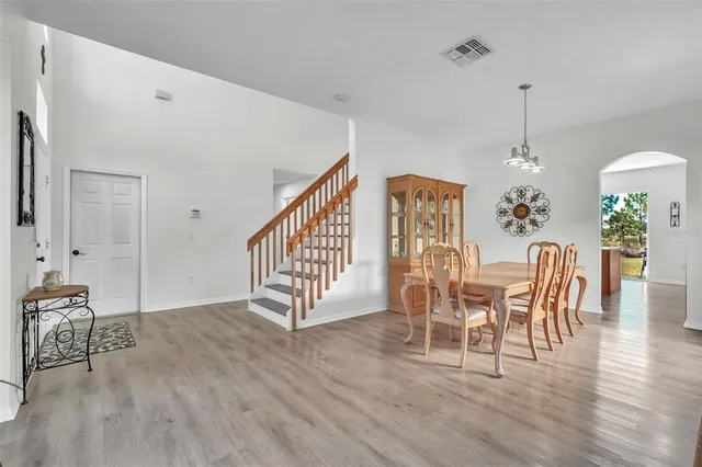 a dining room with furniture entryway and wooden floor