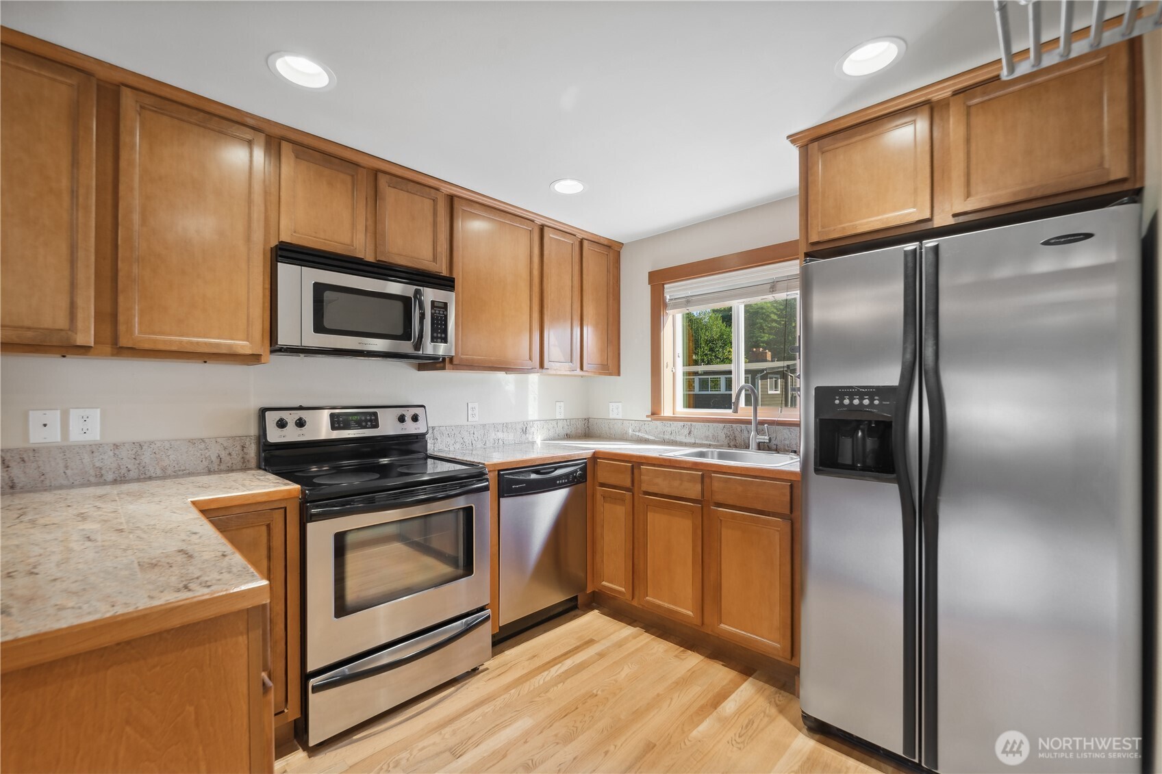 9228 15th Avenue Southwest, Unit B Seattle, WA 98106 - Photo 5 of 16 a kitchen with stainless steel appliances granite countertop a refrigerator a stove a sink and a microwave