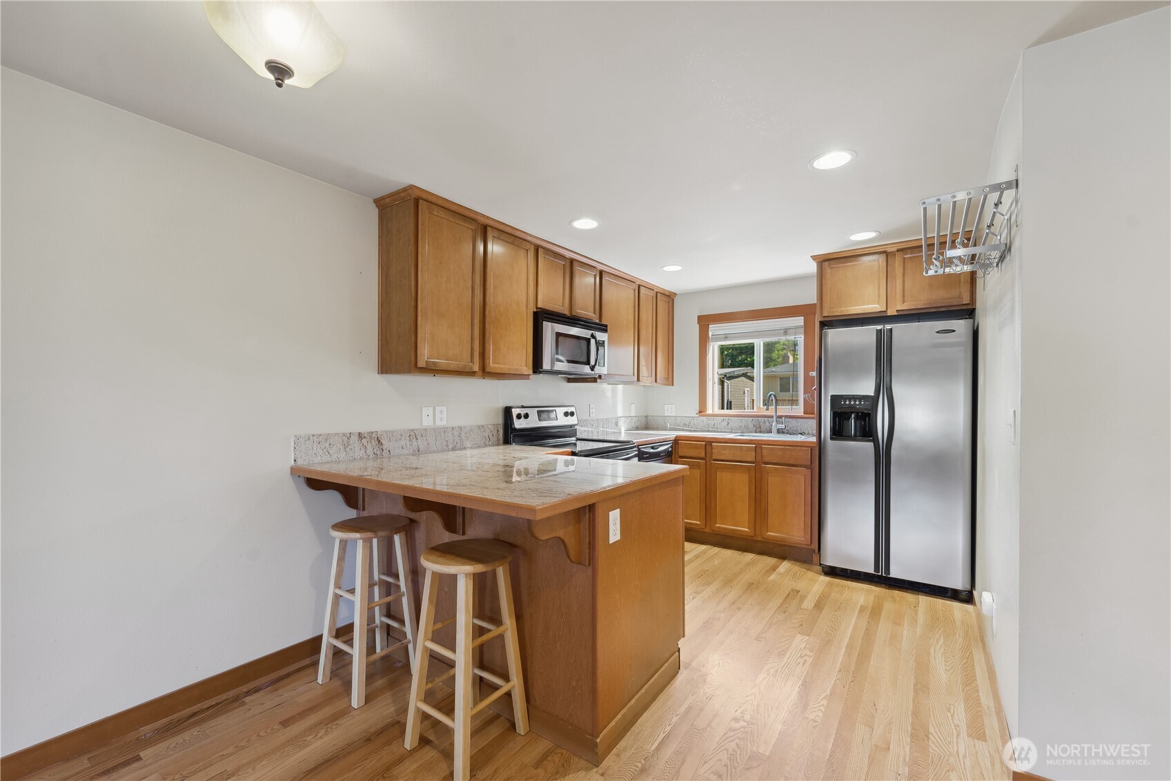 9228 15th Avenue Southwest, Unit B Seattle, WA 98106 - Photo 6 of 16 a kitchen with wooden cabinets refrigerator and microwave