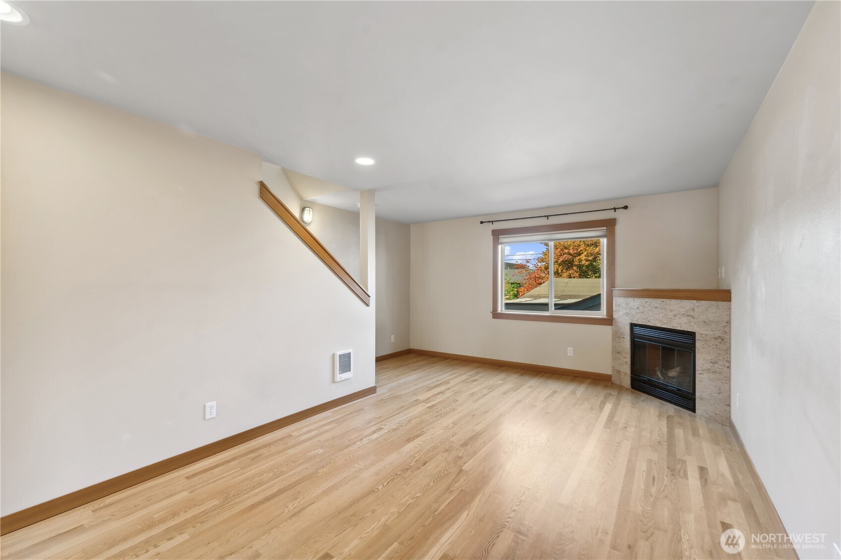 9228 15th Avenue Southwest, Unit B Seattle, WA 98106 - Photo 7 of 16 an empty room with wooden floor fireplace and windows