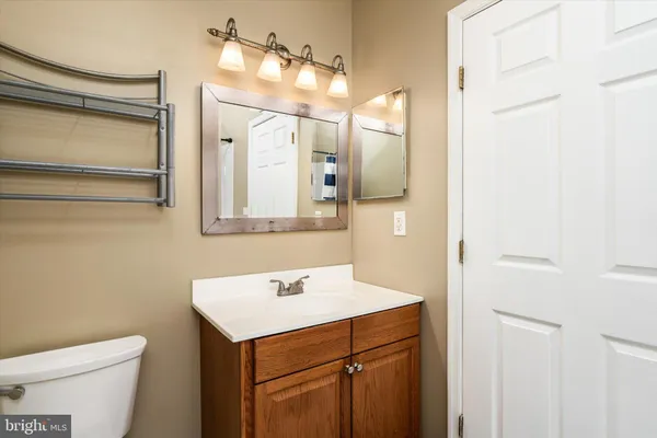 a bathroom with a sink mirror vanity and toilet