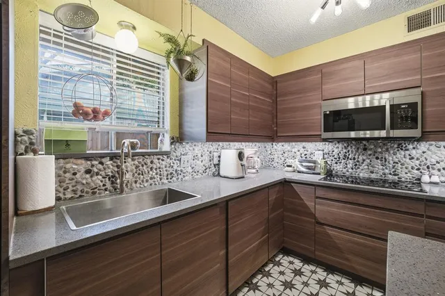 a kitchen with stainless steel appliances wooden cabinets a sink and a microwave