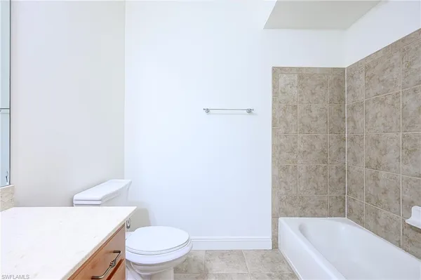 a white toilet sitting next to a bath tub
