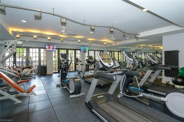 a room with gym equipment and large mirror