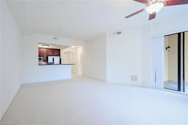 an empty room with window and ceiling fan