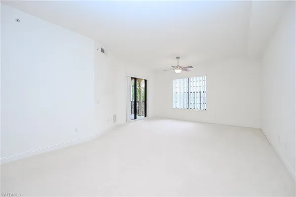 an empty room with windows and cabinet