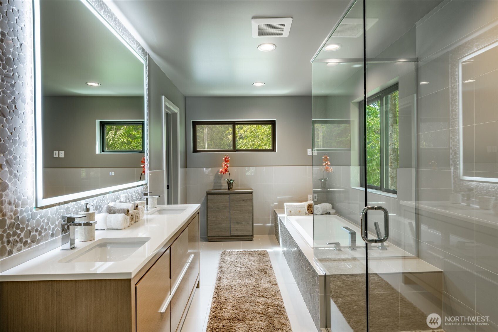 12031 Shuksan Rim Drive Deming, WA 98244 - Photo 21 of 39 a bathroom with a double vanity sink a mirror and a bathtub
