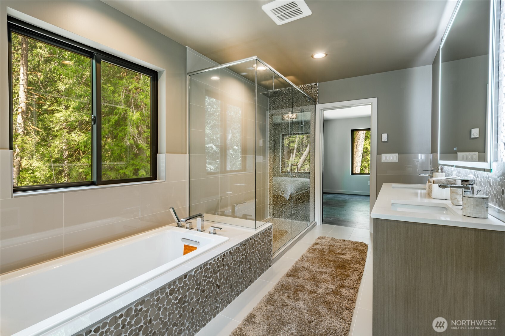 12031 Shuksan Rim Drive Deming, WA 98244 - Photo 22 of 39 a bathroom with a tub a sink and a large mirror