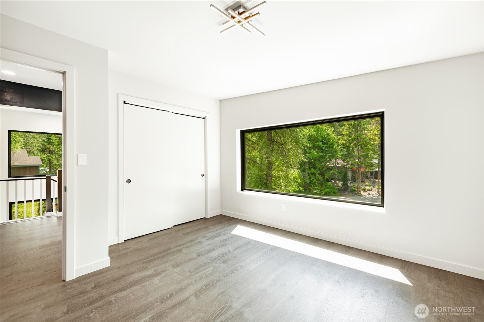 12031 Shuksan Rim Drive Deming, WA 98244 - Photo 27 of 39 an empty room with wooden floor and windows