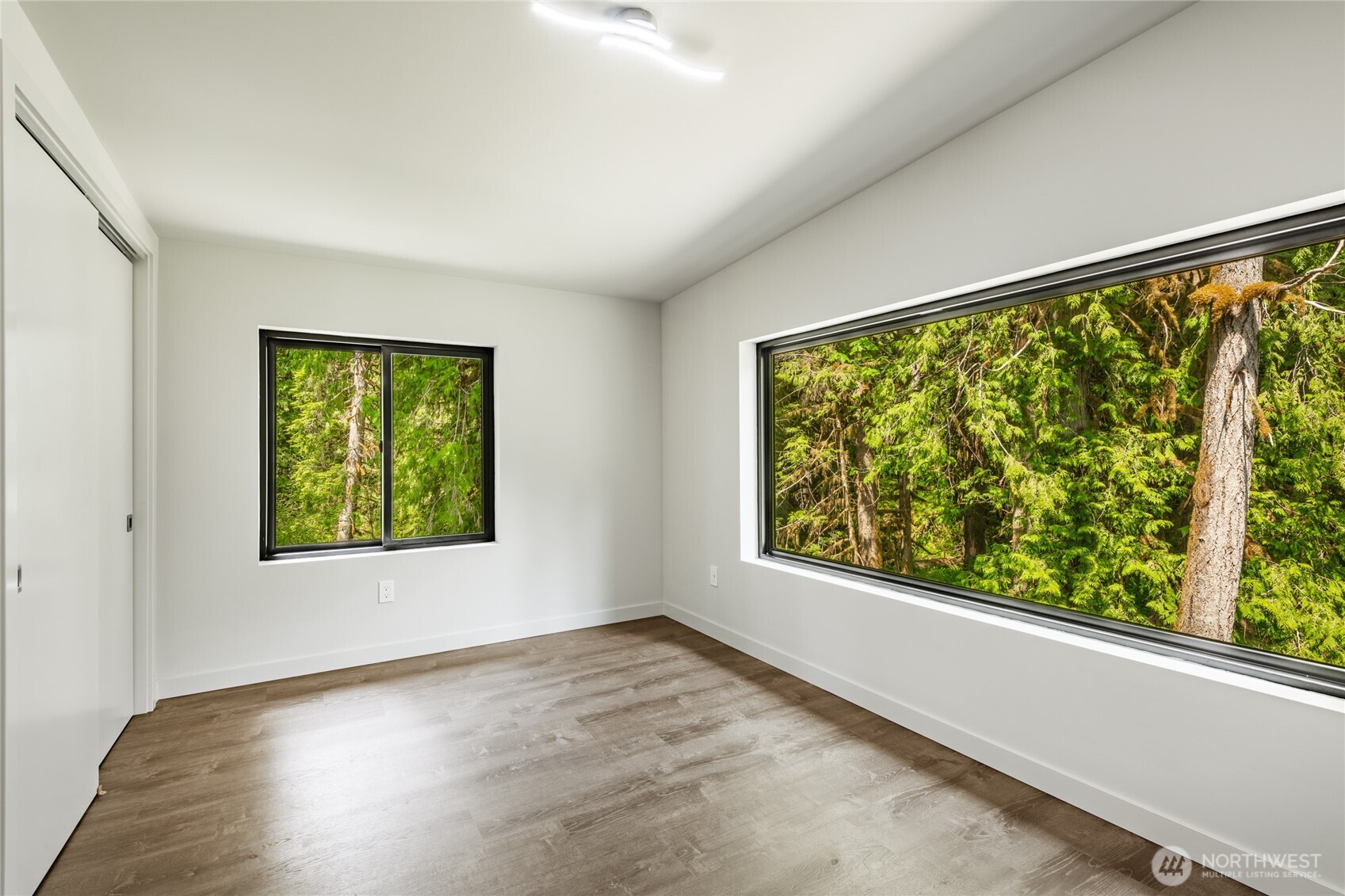 12031 Shuksan Rim Drive Deming, WA 98244 - Photo 29 of 39 a view of an empty room with wooden floor and a window