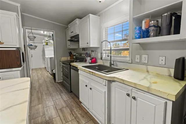 a kitchen with stainless steel appliances granite countertop a sink stove and cabinets