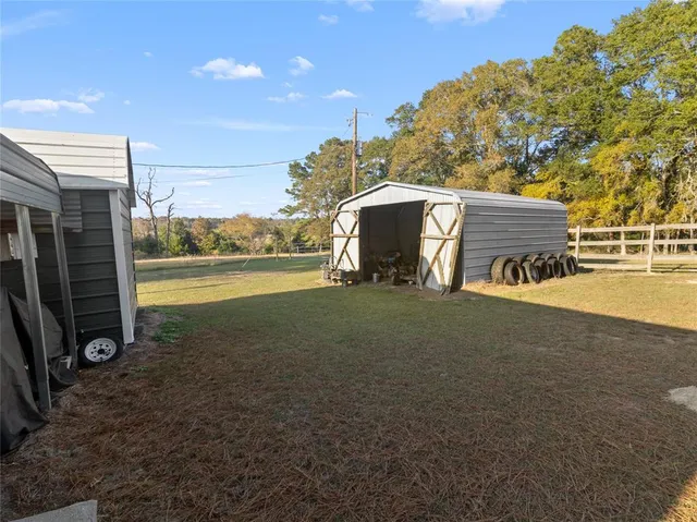 a view of a house with backyard and furniture