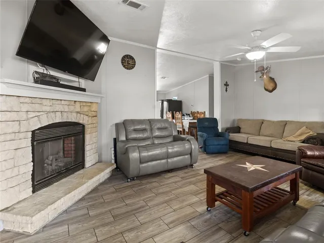 a living room with furniture a flat screen tv and a fireplace