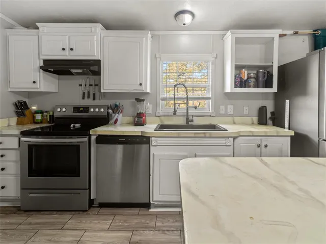 a kitchen with stainless steel appliances a stove sink and cabinets