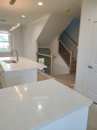a view of a hallway to a room with stairs and a window