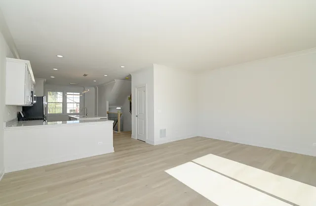 a view of kitchen and hall with wooden floor