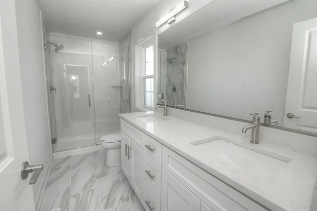 a bathroom with a double vanity sink mirror double and shower
