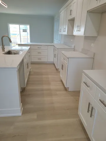 a view of kitchen and hall with wooden floor