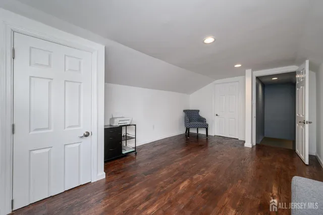 an empty room with wooden floor and a sink