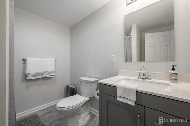 a bathroom with a granite countertop toilet sink and mirror