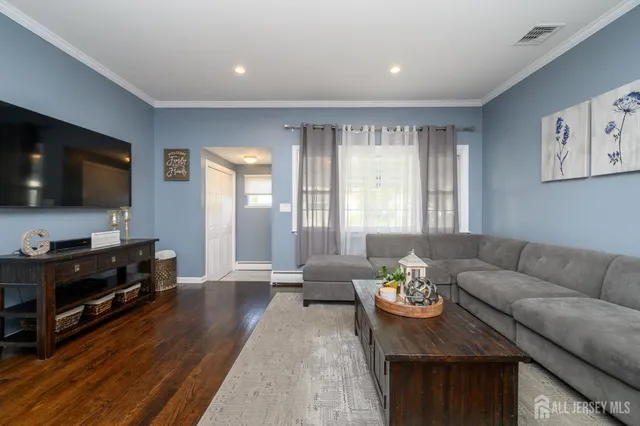 a living room with furniture a flat screen tv and a window
