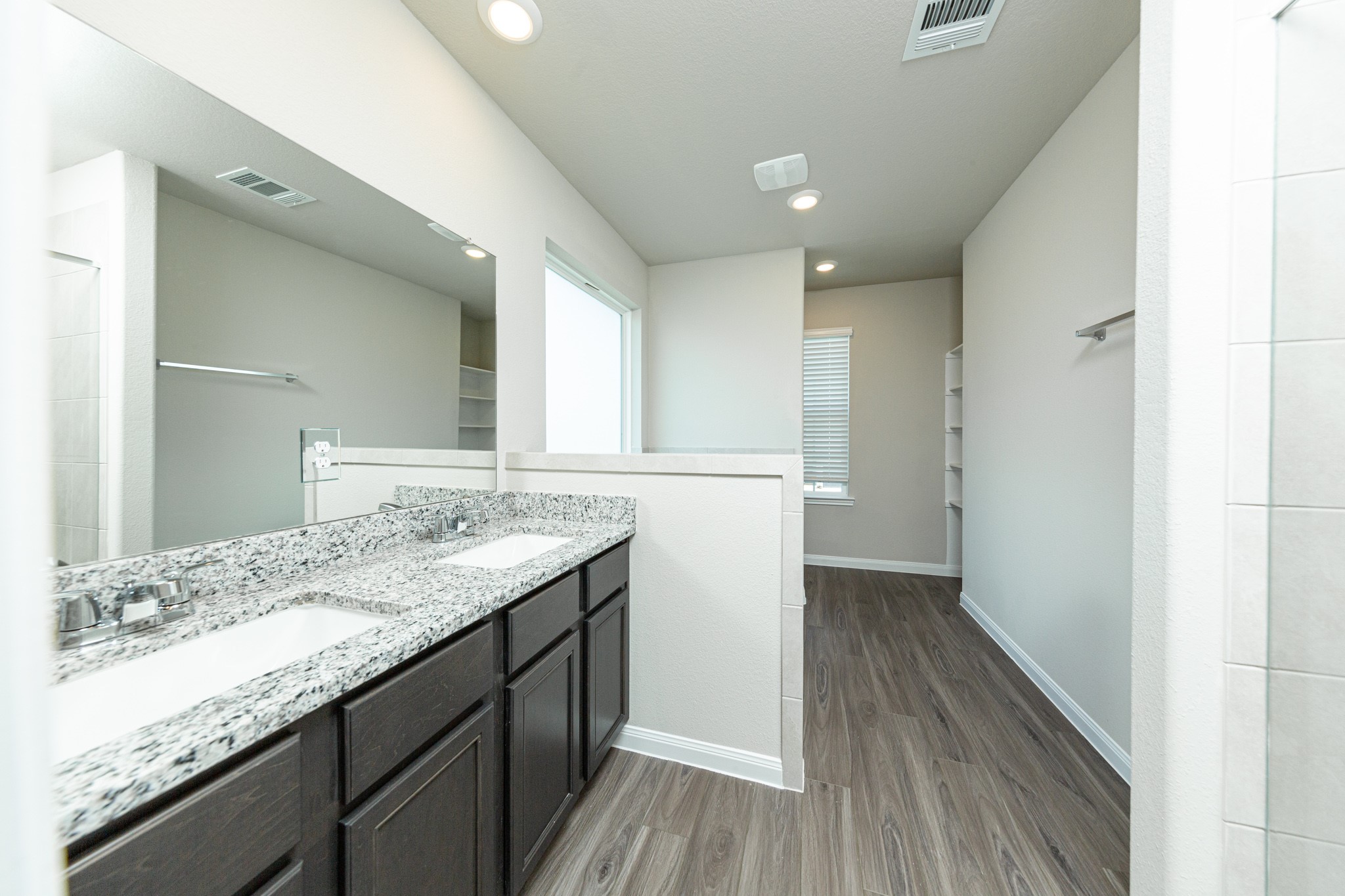 13663 Kit Run Splendora, TX 77372 - Photo 16 of 28 a bathroom with a granite countertop sink a mirror and wooden floor