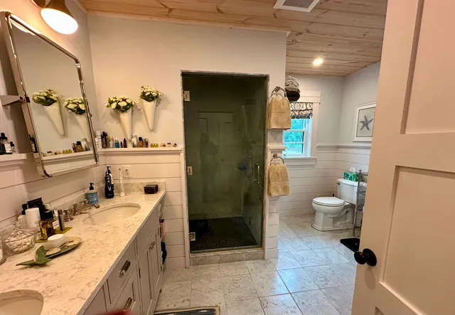 a bathroom with a granite countertop sink mirror vanity and toilet