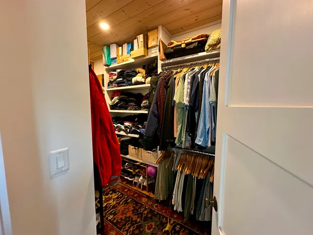 a view of walk in closet with clothes and shoes