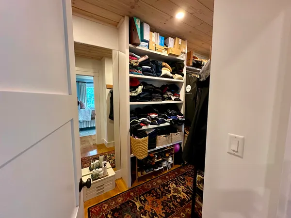 a view of walk in closet with clothes and shoes