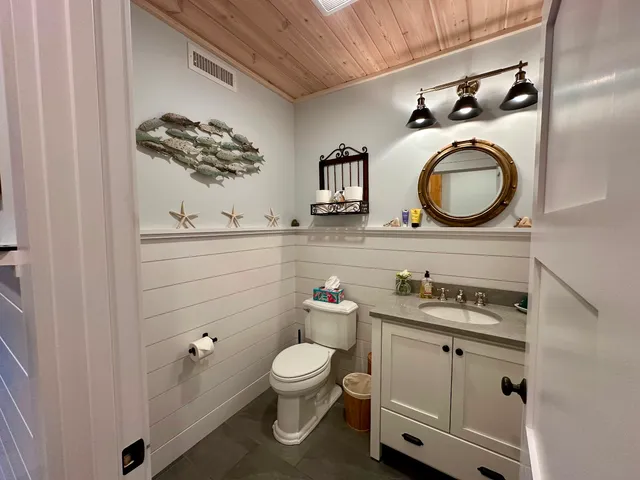 a bathroom with a granite countertop toilet sink and mirror