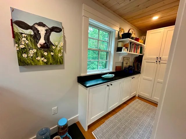 a hallway with painting on the wall and a window