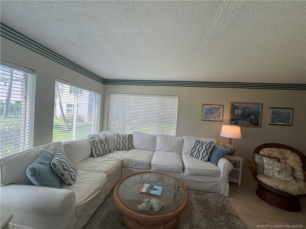 1501 Northeast Ocean Boulevard, Unit 9 Stuart, FL 34996 - Photo 14 of 41 a living room with furniture and a large window
