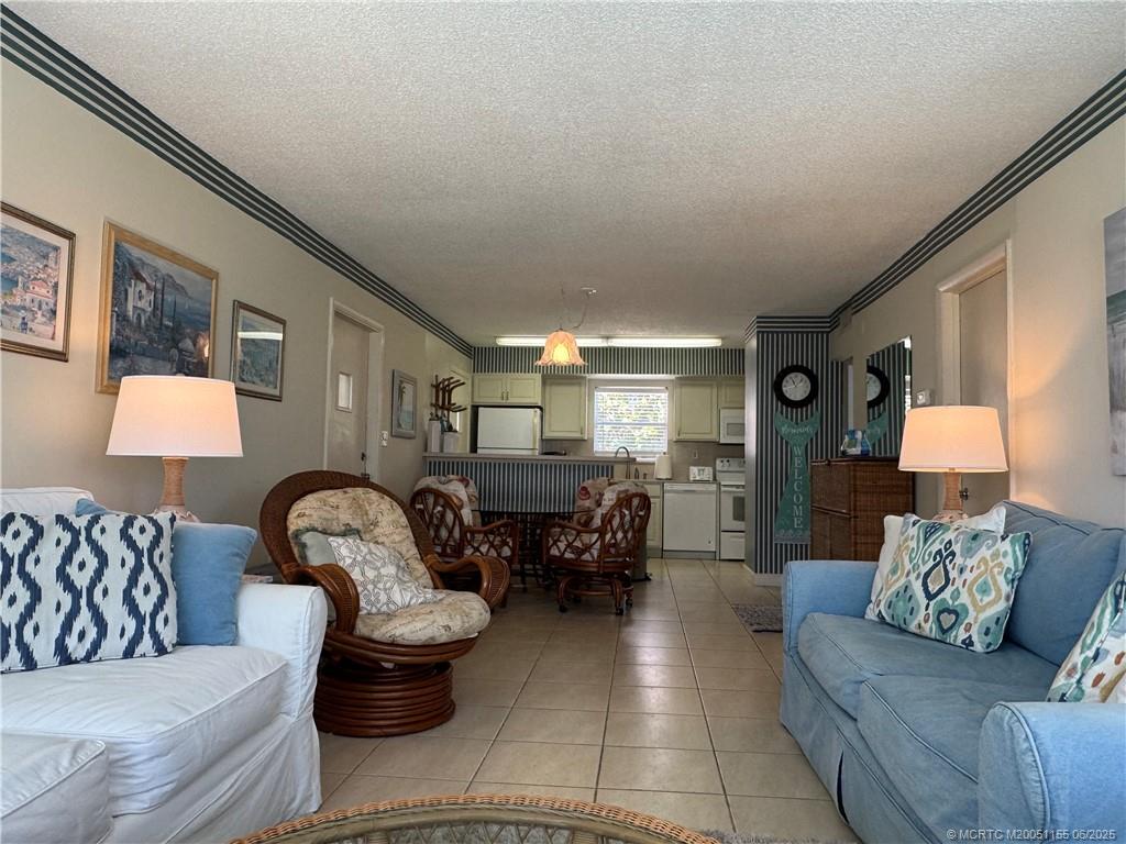 1501 Northeast Ocean Boulevard, Unit 9 Stuart, FL 34996 - Photo 16 of 41 a living room with furniture and a lamp