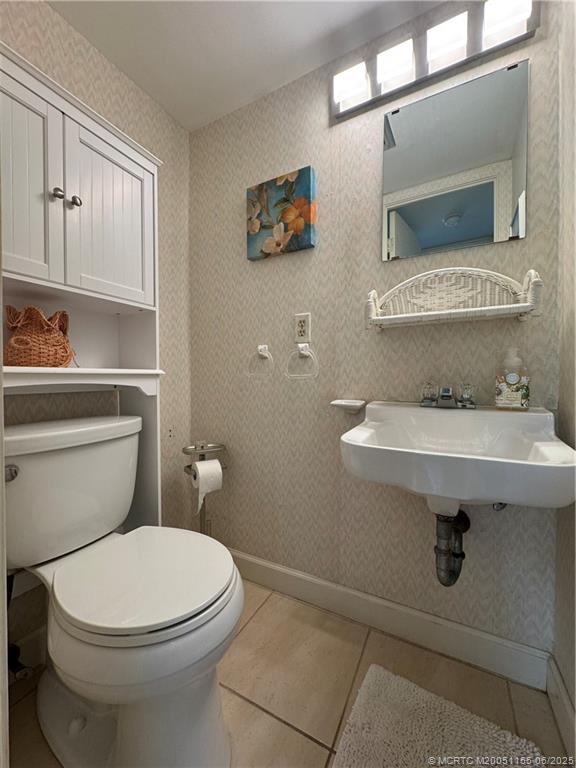 1501 Northeast Ocean Boulevard, Unit 9 Stuart, FL 34996 - Photo 23 of 41 a bathroom with a sink a mirror and a toilet