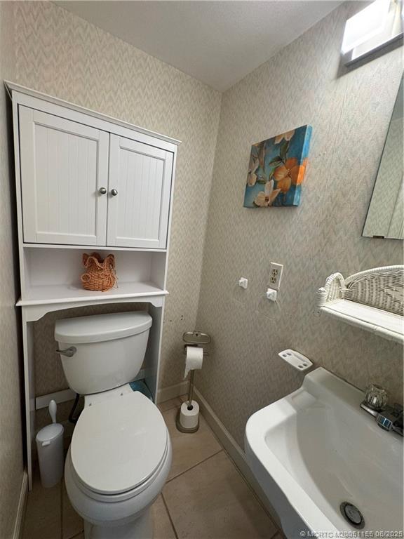 1501 Northeast Ocean Boulevard, Unit 9 Stuart, FL 34996 - Photo 24 of 41 a bathroom with a toilet a sink and mirror