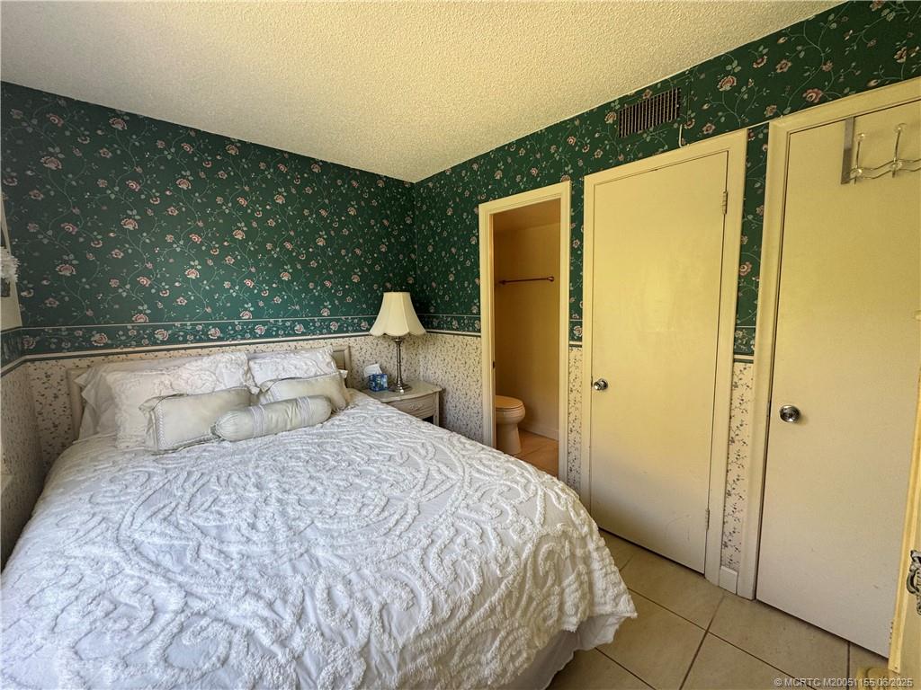 1501 Northeast Ocean Boulevard, Unit 9 Stuart, FL 34996 - Photo 26 of 41 a bedroom with a large bed and wooden door