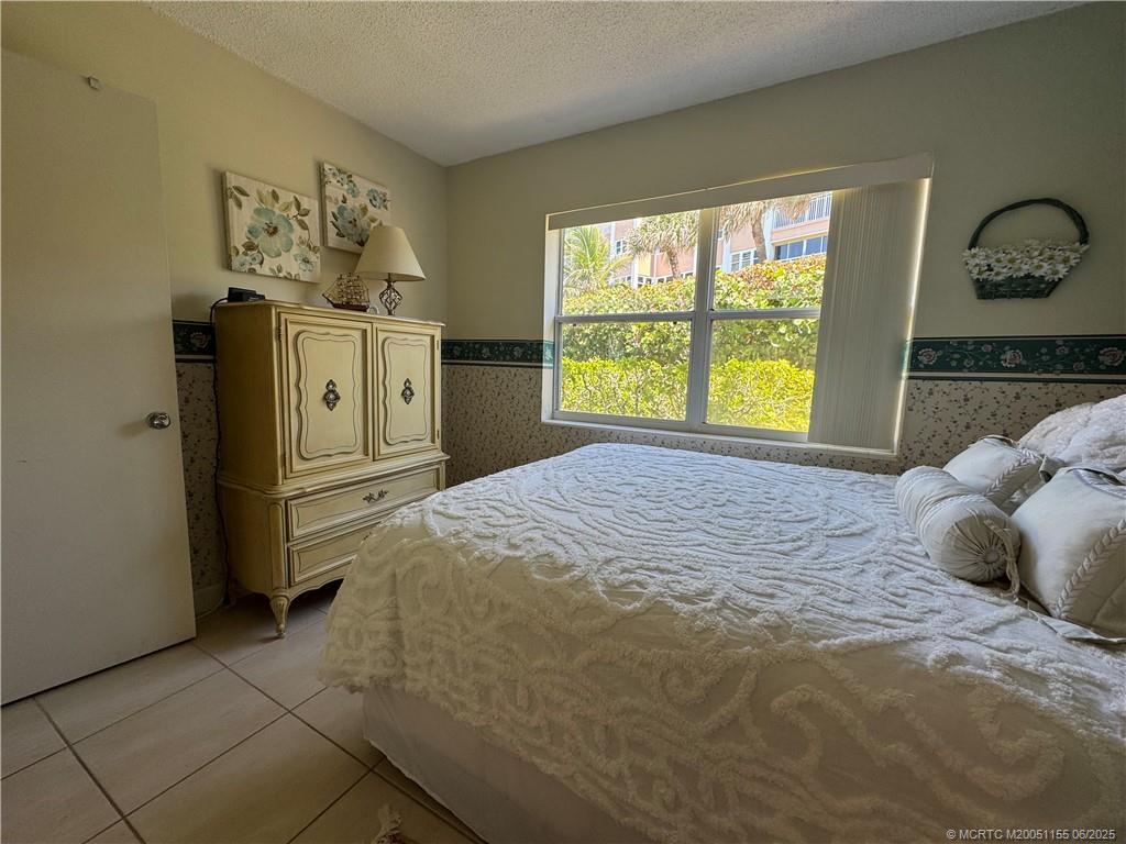 1501 Northeast Ocean Boulevard, Unit 9 Stuart, FL 34996 - Photo 27 of 41 a bedroom with a bed and a window