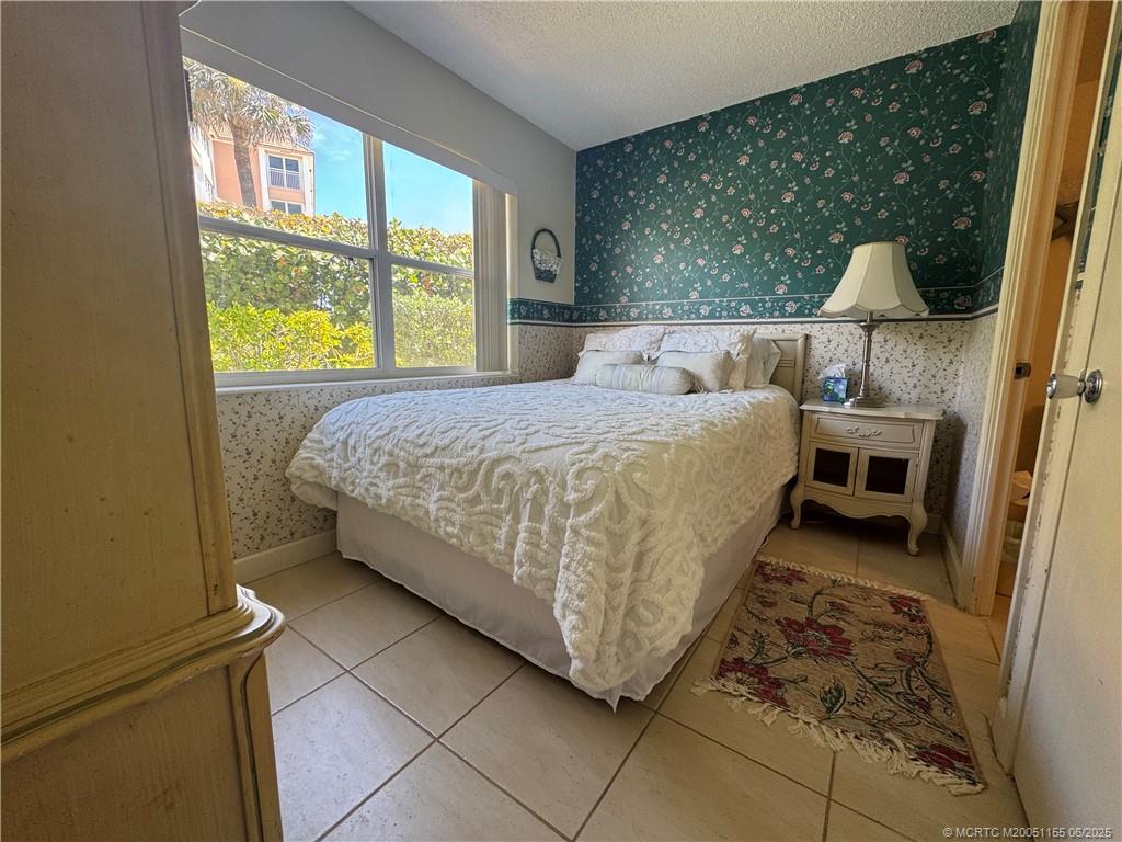 1501 Northeast Ocean Boulevard, Unit 9 Stuart, FL 34996 - Photo 28 of 41 a bed sitting in a bedroom next to a window