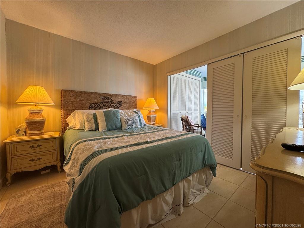 1501 Northeast Ocean Boulevard, Unit 9 Stuart, FL 34996 - Photo 32 of 41 a bedroom with a bed and a cabinets