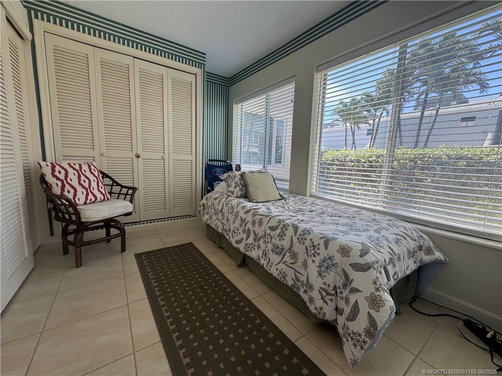1501 Northeast Ocean Boulevard, Unit 9 Stuart, FL 34996 - Photo 34 of 41 a bed sitting in a bedroom next to a window