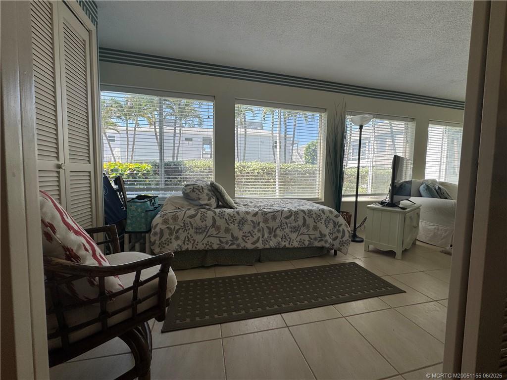 1501 Northeast Ocean Boulevard, Unit 9 Stuart, FL 34996 - Photo 35 of 41 a bedroom with a bed and large windows