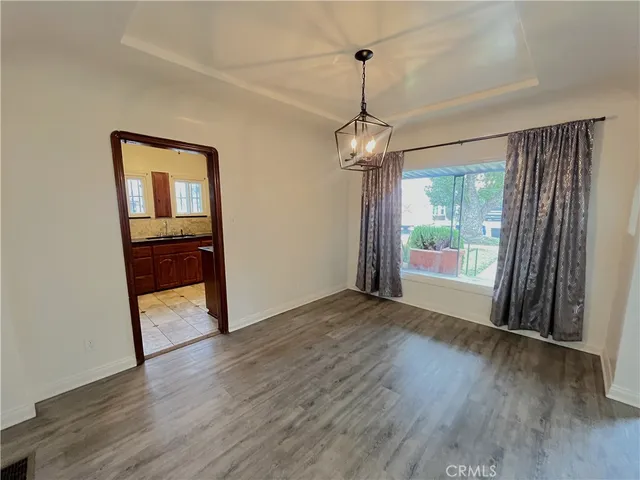 a view of empty room with wooden floor and window
