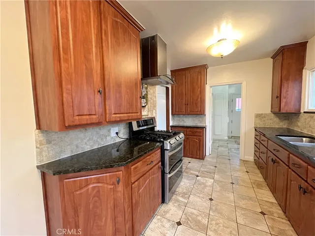 a kitchen with stainless steel appliances granite countertop a stove a sink and a microwave