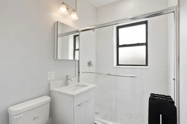 a bathroom with a sink toilet and window
