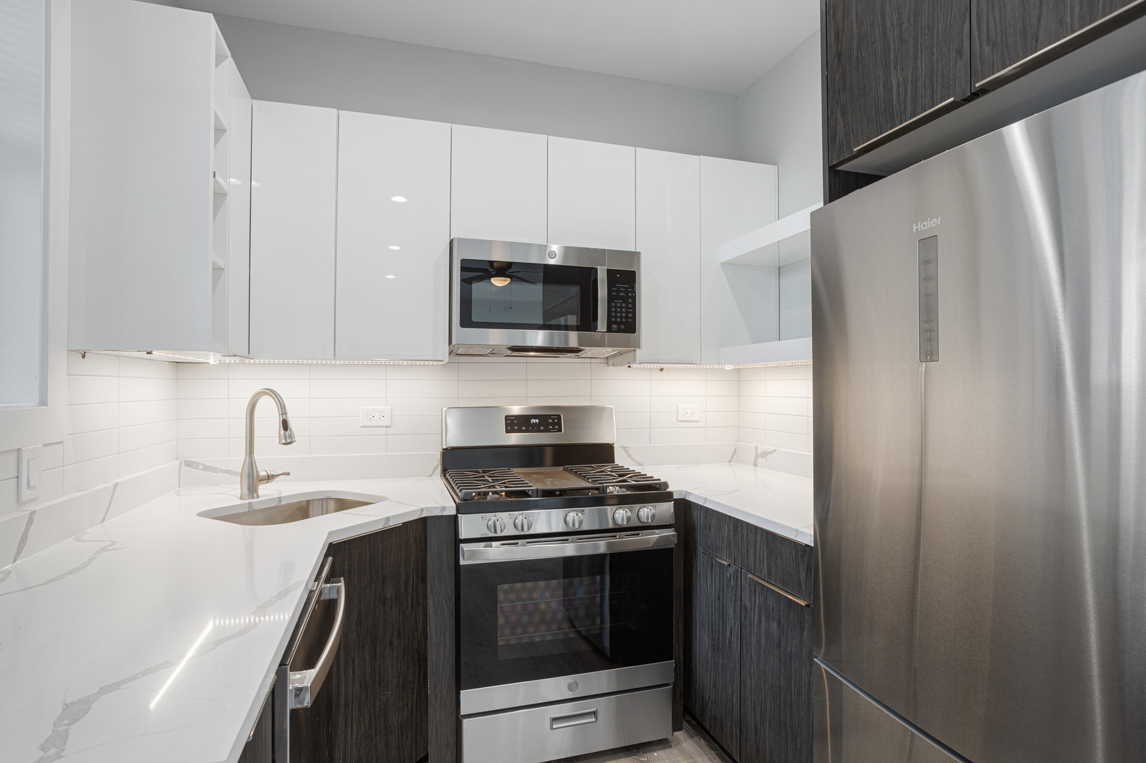 1243 West Morse Avenue, Unit 2 Chicago, IL 60626 - Photo 4 of 13 a kitchen with refrigerator a microwave a sink and cabinets